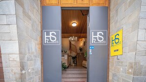 A hotel entrance with a reception desk, a chandelier, and a staircase leading to the upper floor. - Hotel Residence Sestriere (Moncalieri)