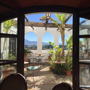 A patio with a view of mountains, featuring outdoor furniture and potted plants. - Casa Henrietta (Jimena de la Frontera)