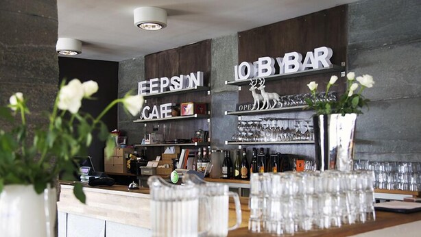 A bar area with shelves labeled 'EIPSION CAFE' and 'JOBYBAR'. - Hordatun Hotel (Ullensvang)