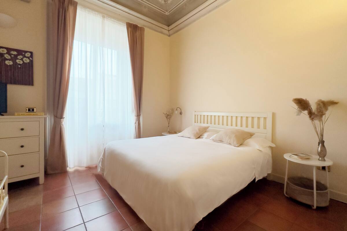 A neatly arranged bedroom with a bed, bedside table, and a dresser.