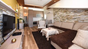 Ein modernes Wohnzimmer mit Kamin, einer Couch und einem Essbereich.