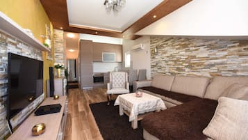 Apartamento exclusivo, 2 quartos, vista para o mar | Área de estar | TV de tela plana 54 cm com canais a cabo, TV, console de videogame