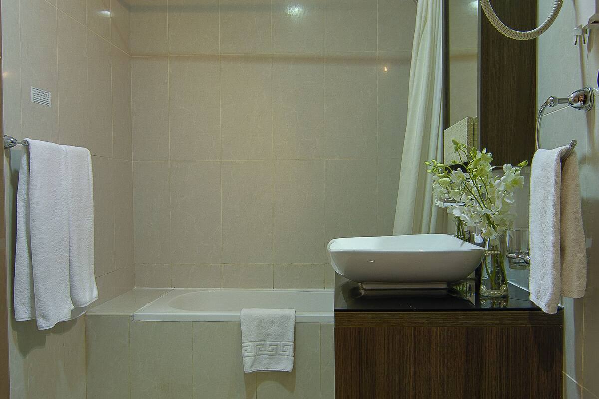 Deep soaking tub, rainfall showerhead, designer toiletries, slippers