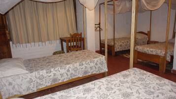 Una habitación con dos camas individuales, una silla de madera y una mesita.