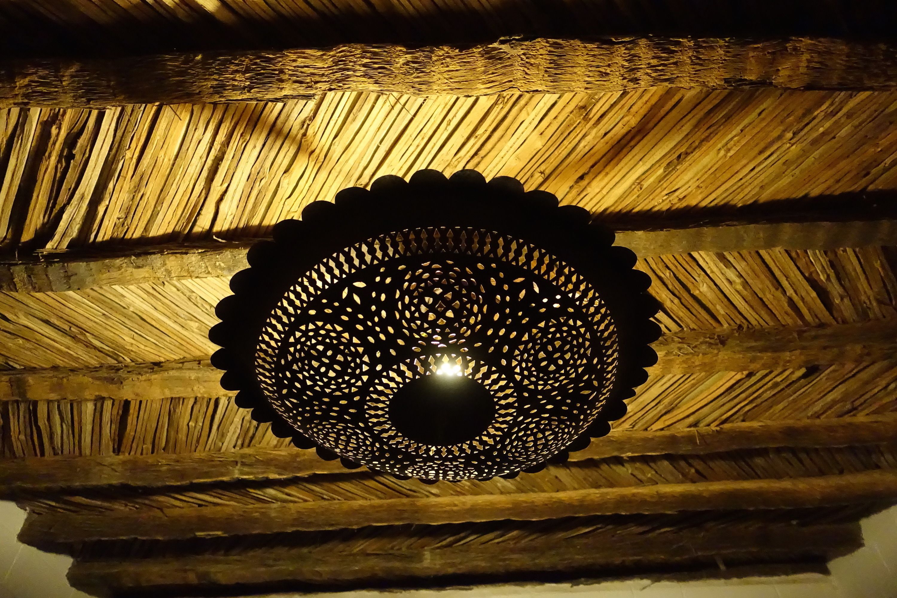 A ceiling with a circular, perforated light fixture.