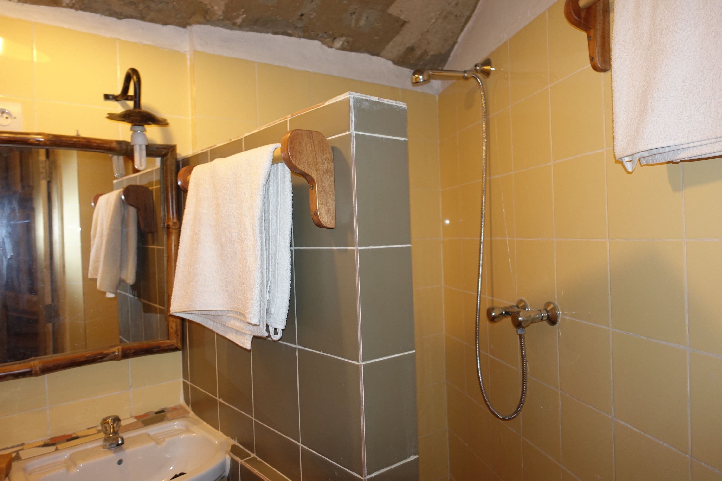 A bathroom with a sink, mirror, and shower.