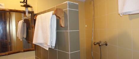 A bathroom with a sink, mirror, and shower.