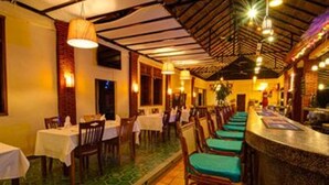 A restaurant with tables and chairs, a counter, and a tiled floor.