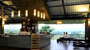 A restaurant with a bar area, wooden ceiling, hanging lights, and a view of the outdoors. - Chiangmai Inthanon Golf and Natural Resort (Doi Lo)