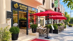 The exterior of the Albinas Hotel with a red umbrella and outdoor seating area. - Albinas Hotel Old City (Istanbul)