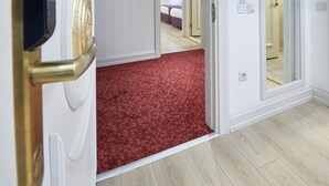 A hotel room with a red carpet, white walls, and a wooden floor. - Albinas Hotel Old City (Istanbul)