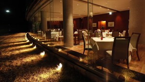 A restaurant with a glass wall, tables, chairs, and a decorative light strip along the floor. - Nasu Sunlight Hotel (Nasu)