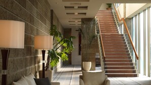 A spacious lobby with a modern staircase, a sofa set, and potted plants. - Nasu Sunlight Hotel (Nasu)