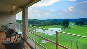 A balcony with a view of a golf course, including a pond and trees. - Nasu Sunlight Hotel (Nasu)