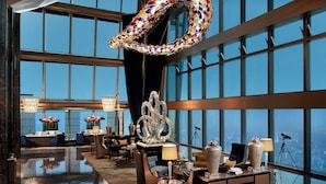 A spacious lobby with a high ceiling, large windows, and a central decorative sculpture. - The St. Regis Shenzhen (Shenzhen)