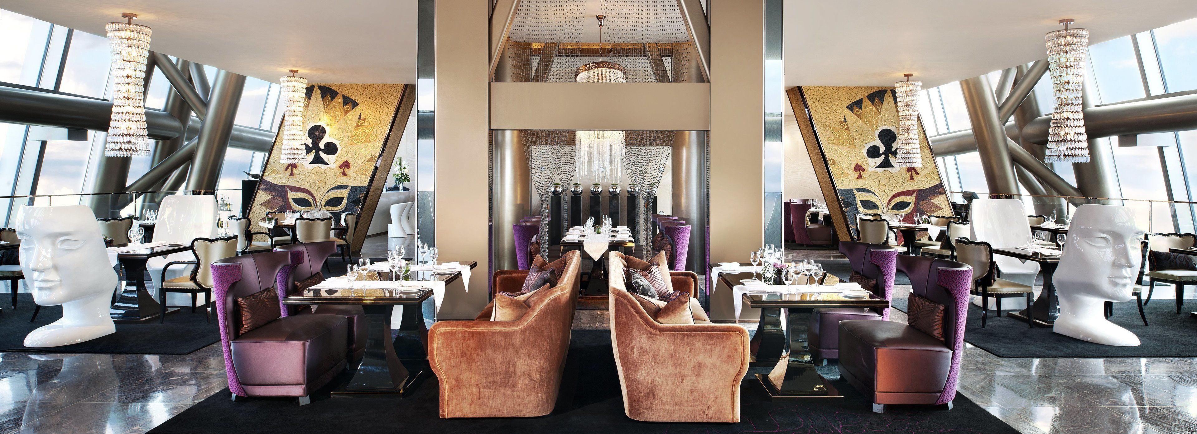 Un espace de restauration luxueux, doté de hauts plafonds, de lustres et de mobilier moderne.