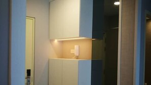 A modern, well-lit room with built-in cabinets and a bench. - Casa Blanca Guest House (Malacca City)