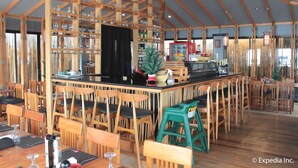 A spacious indoor dining area with wooden furniture and a central bar. - Subic Grand Seas Resort (Olongapo)
