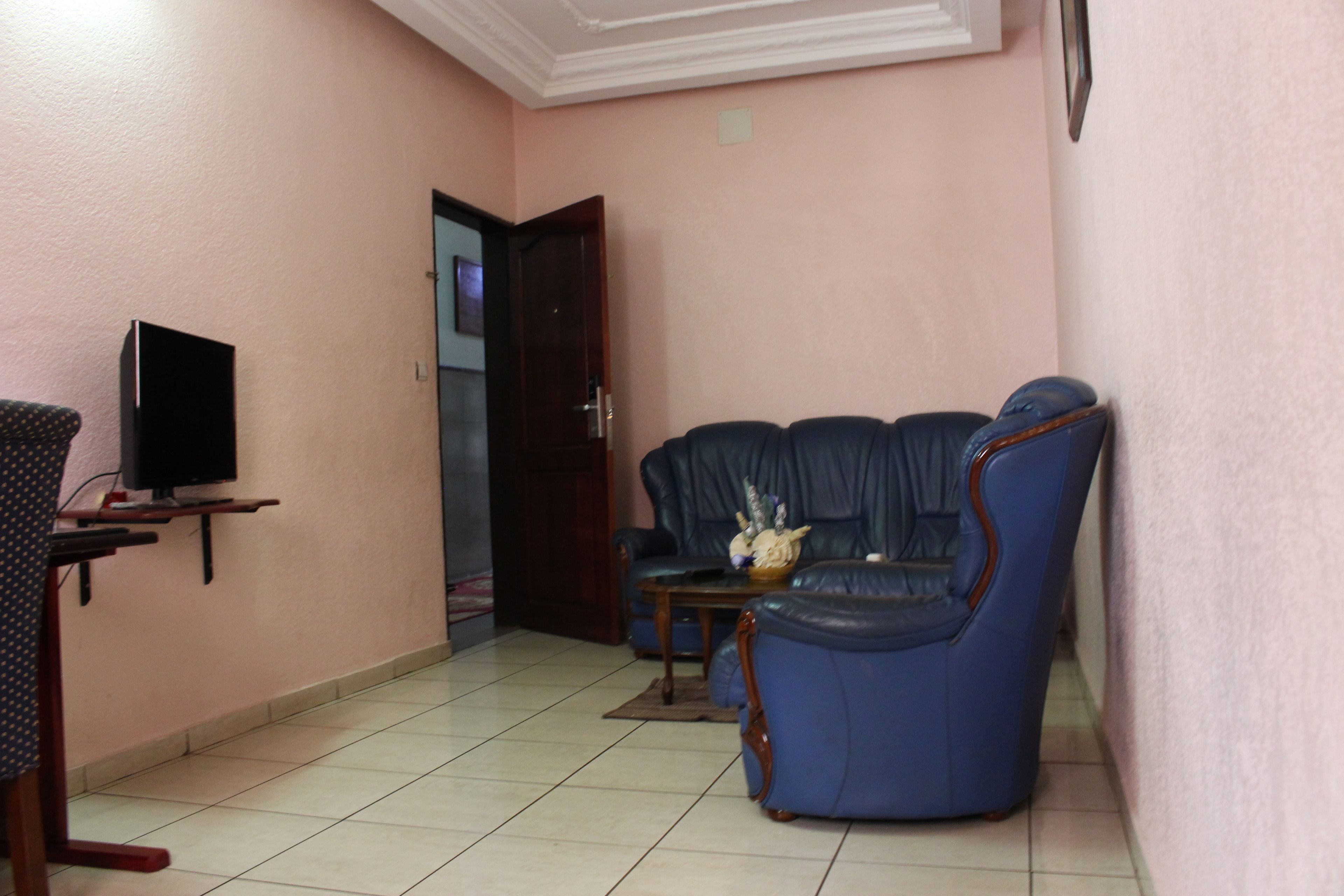 A living room with a television on a stand, a sofa, and a coffee table.