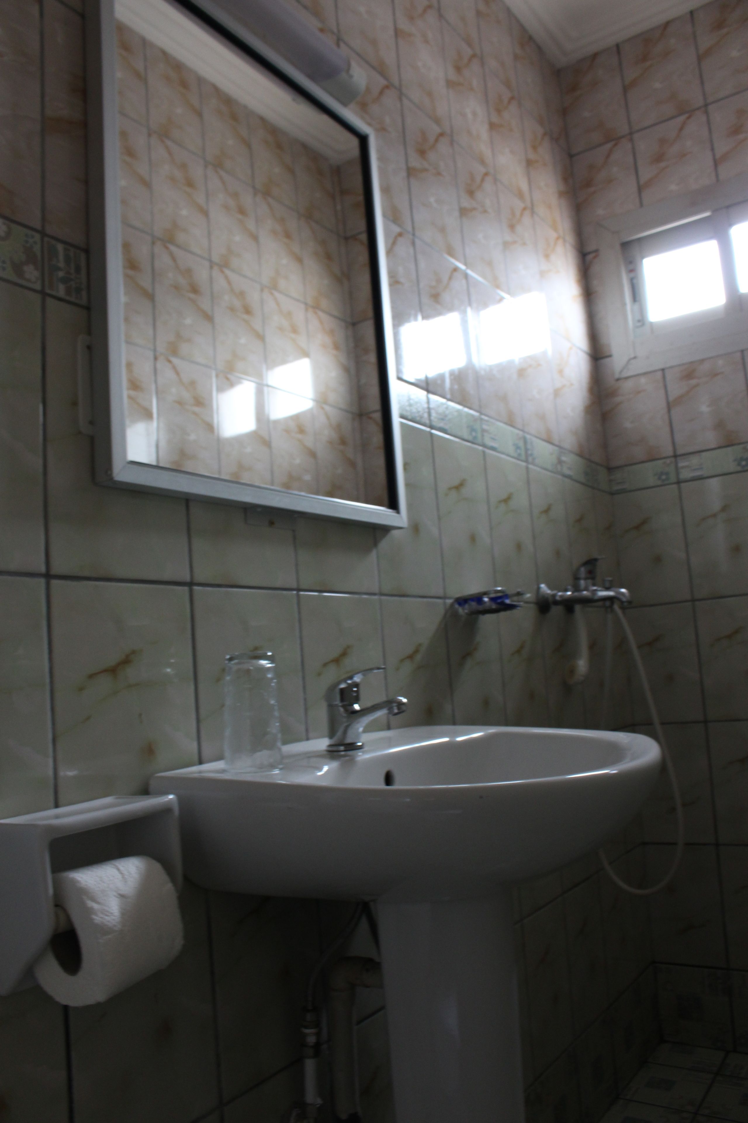 Un baño con lavamanos, espejo y ducha.