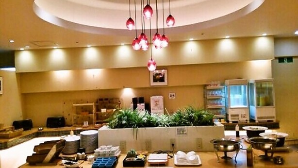 A hotel lobby with a reception desk, plants, and a large window. - Hotel Crown Hills Himeji (Himeji)