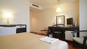 A hotel room with a bed, a desk with a chair, a desk lamp, a television, and a mirror. - Hotel Crown Hills Himeji (Himeji)