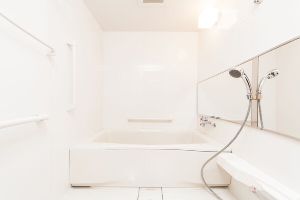 A modern bathroom with a bathtub, a shower, and a large mirror. - Hotel MyStays Sakaisuji Honmachi (Osaka)