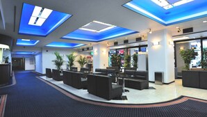 A modern lobby with a curved seating area, a reception desk, and a large window. - Tokyo Business Hotel (Tokyo)