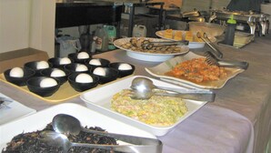A buffet table with various dishes, including bowls of eggs, a tray of fish, and a dish of pasta. - Tokyo Business Hotel (Tokyo)