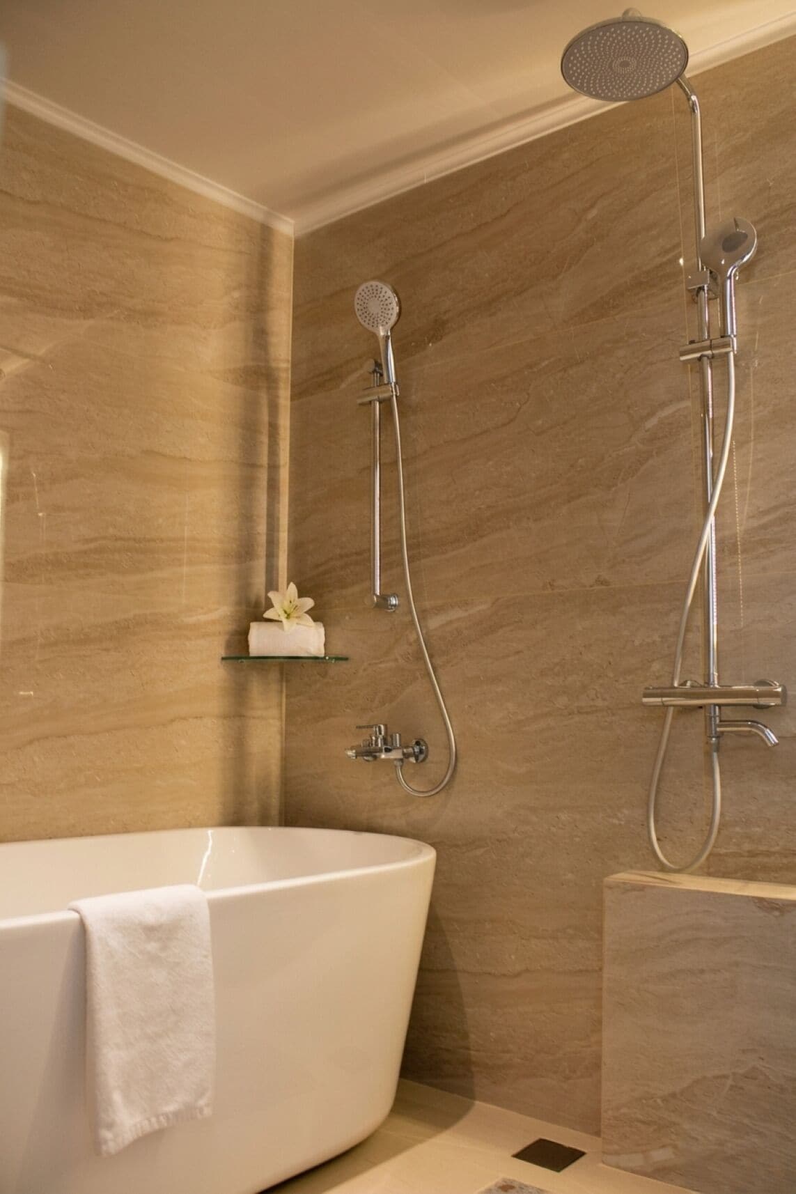 A bathroom with a bathtub, a shower with a handheld showerhead, and a wall-mounted faucet.