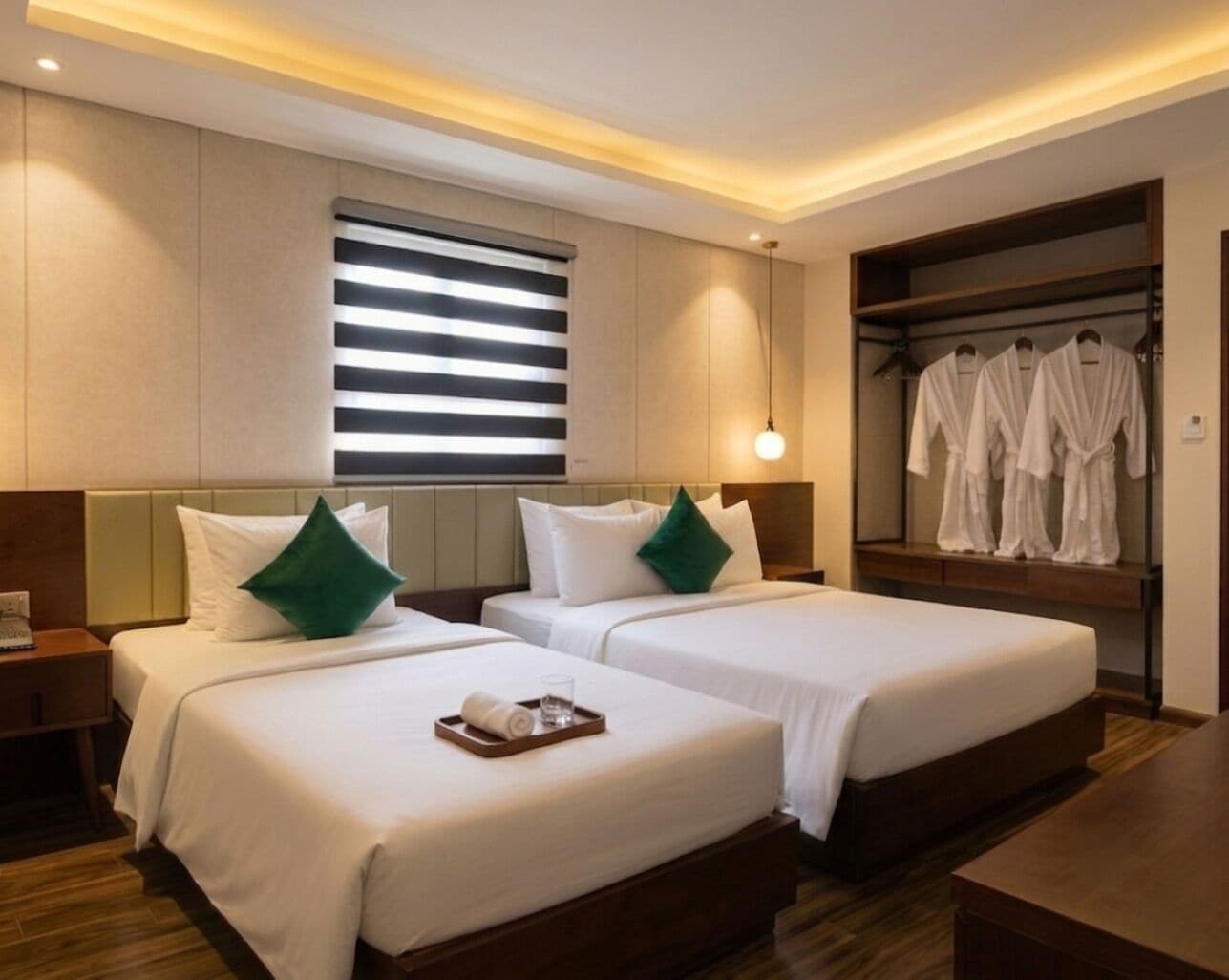 Een hotelkamer met twee bedden, een kledingrek voor jassen en een nachtkastje met een dienblad.