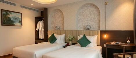 A hotel room with two beds, a nightstand, a chair, and a painting on the wall.