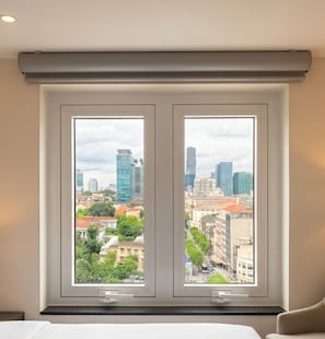 A room with a cityscape view through two windows, a bed, and a bedside table. - Bon Ami Hotel - Thiên Xuân (Ho Chi Minh City)