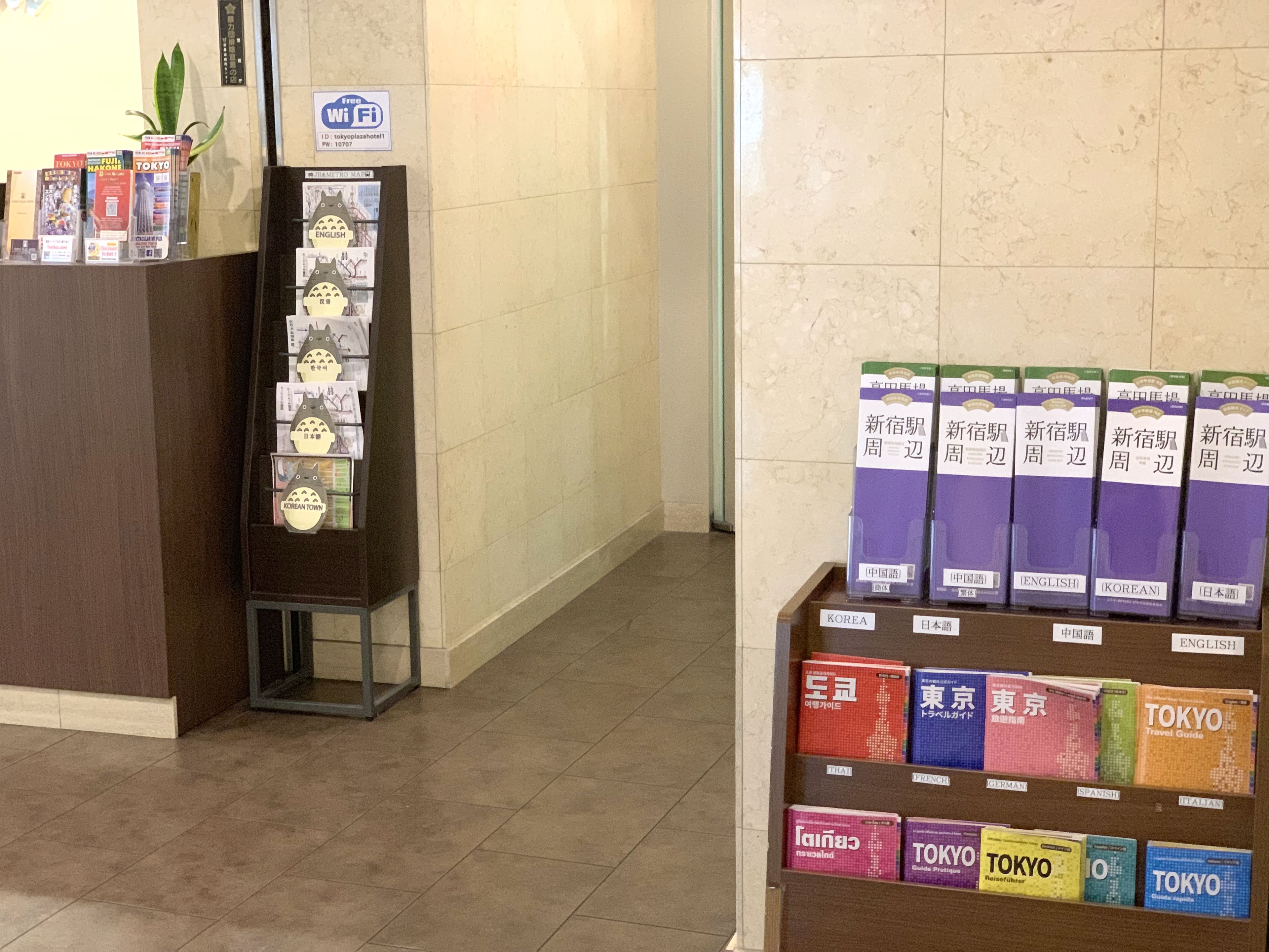 Un'area reception con un banco espositivo di guide turistiche e un cartello che indica la disponibilità del Wi-Fi.