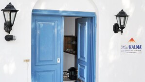 A blue door with a sign above it reading "EENAOXOEO KAAMA".
