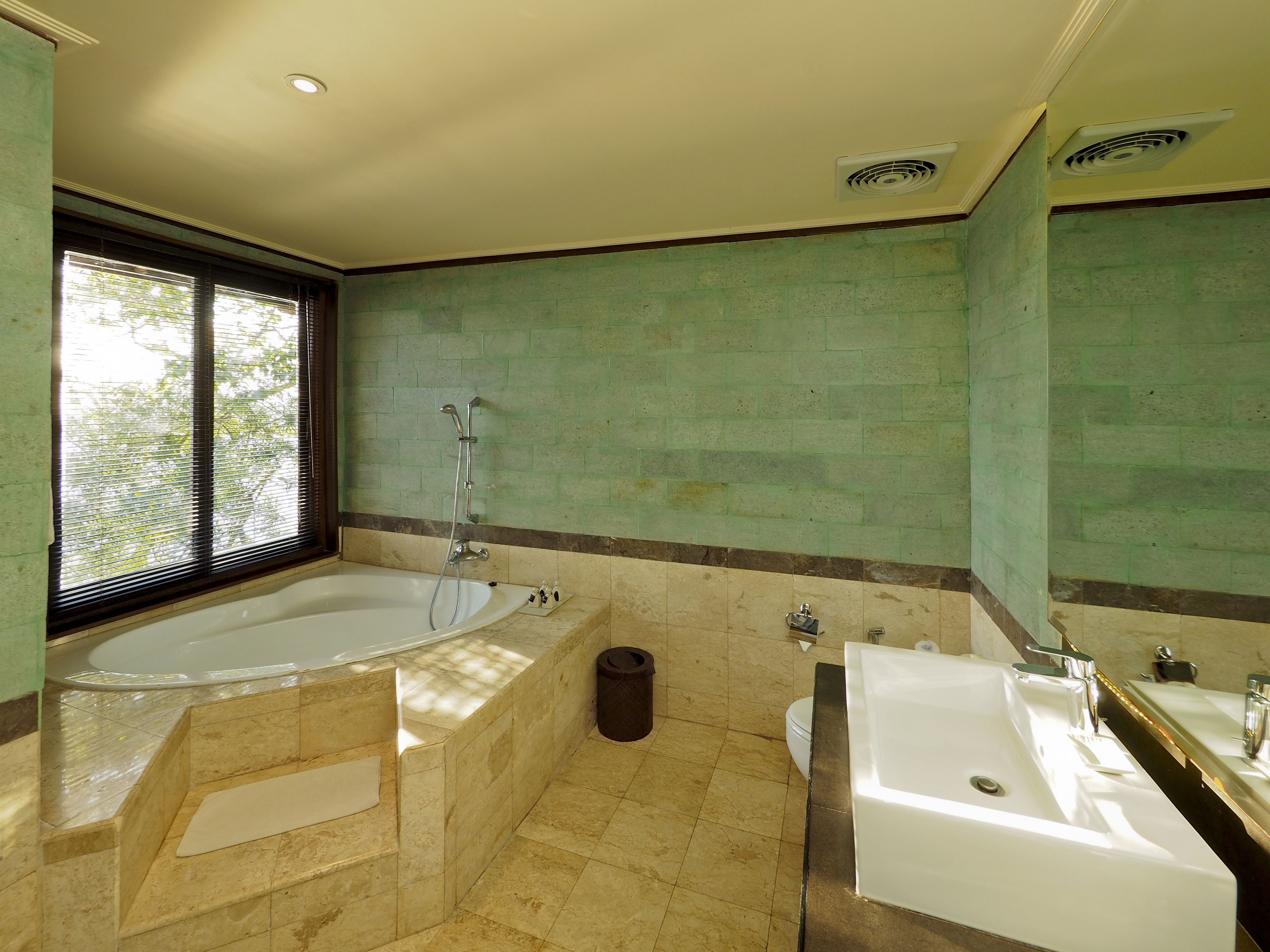 Un baño con bañera, lavamanos e inodoro.