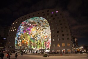 A modern building with a large glass facade reflecting colorful patterns. - Hotel Breitner (Rotterdam)