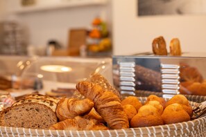 Verschiedene Backwaren in Körben, darunter Brot und Croissants.