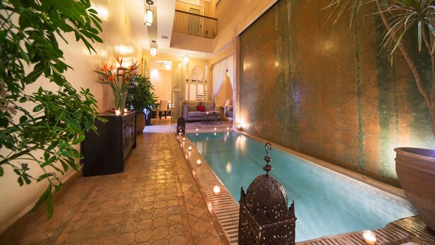 A spa area with a pool, seating, and decorative plants. - Riad Cocoon (Marrakech)
