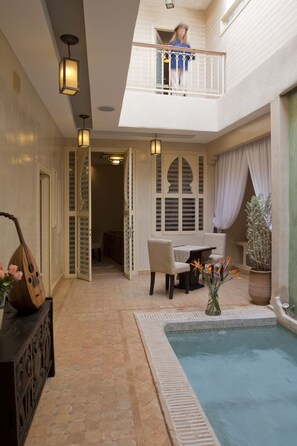 A courtyard with a pool, a dining area, and a balcony. - Riad Cocoon (Marrakech)