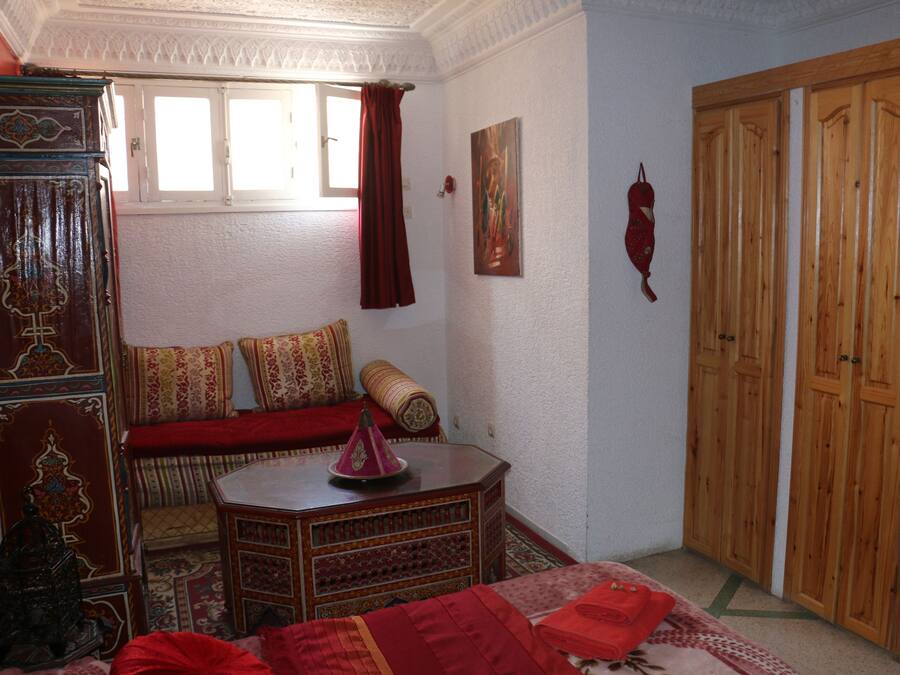 Una habitación con un sofá tradicional, un armario de madera, una mesita con un objeto decorativo y un par de armarios de madera.