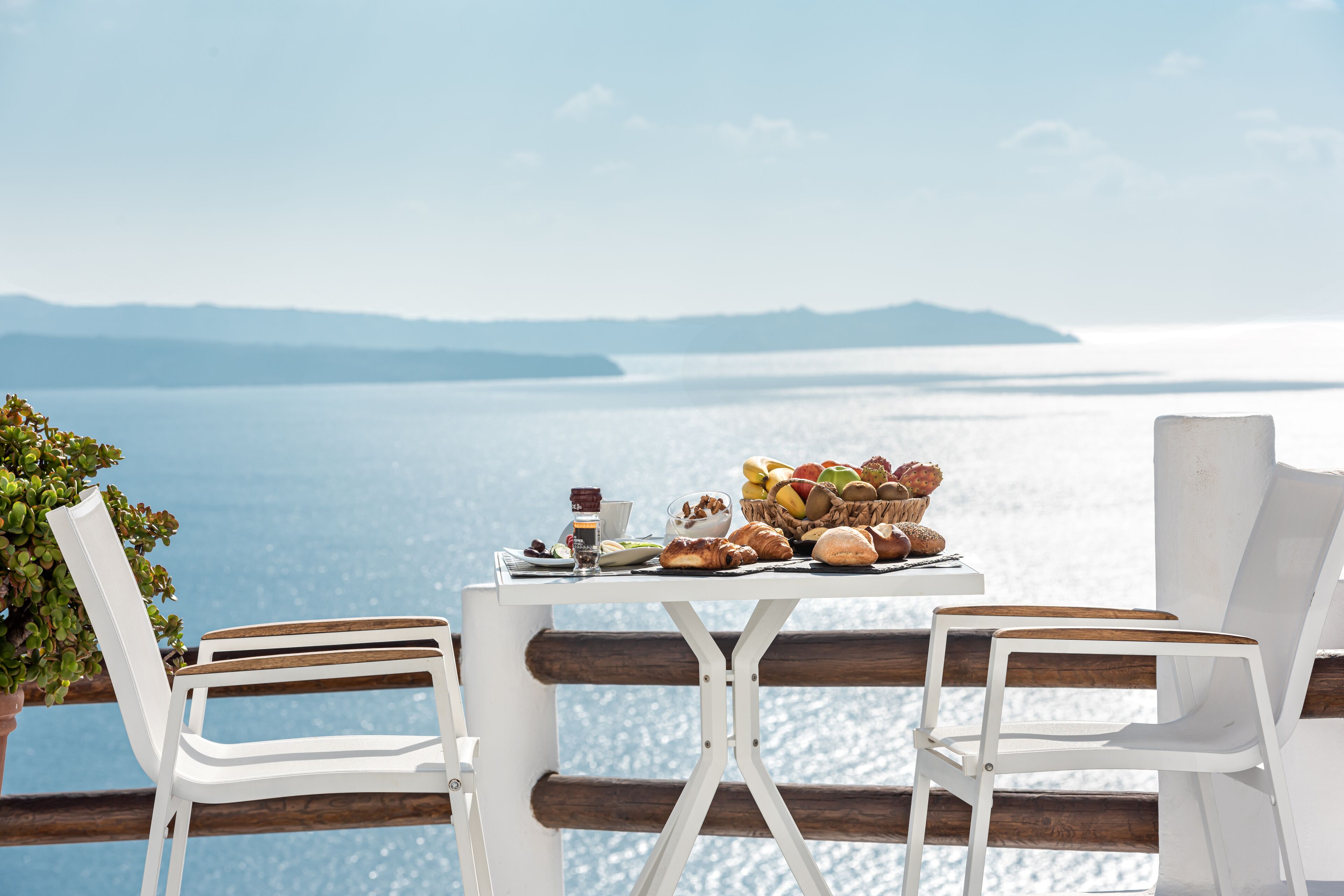 A table with breakfast items and a view of the sea.