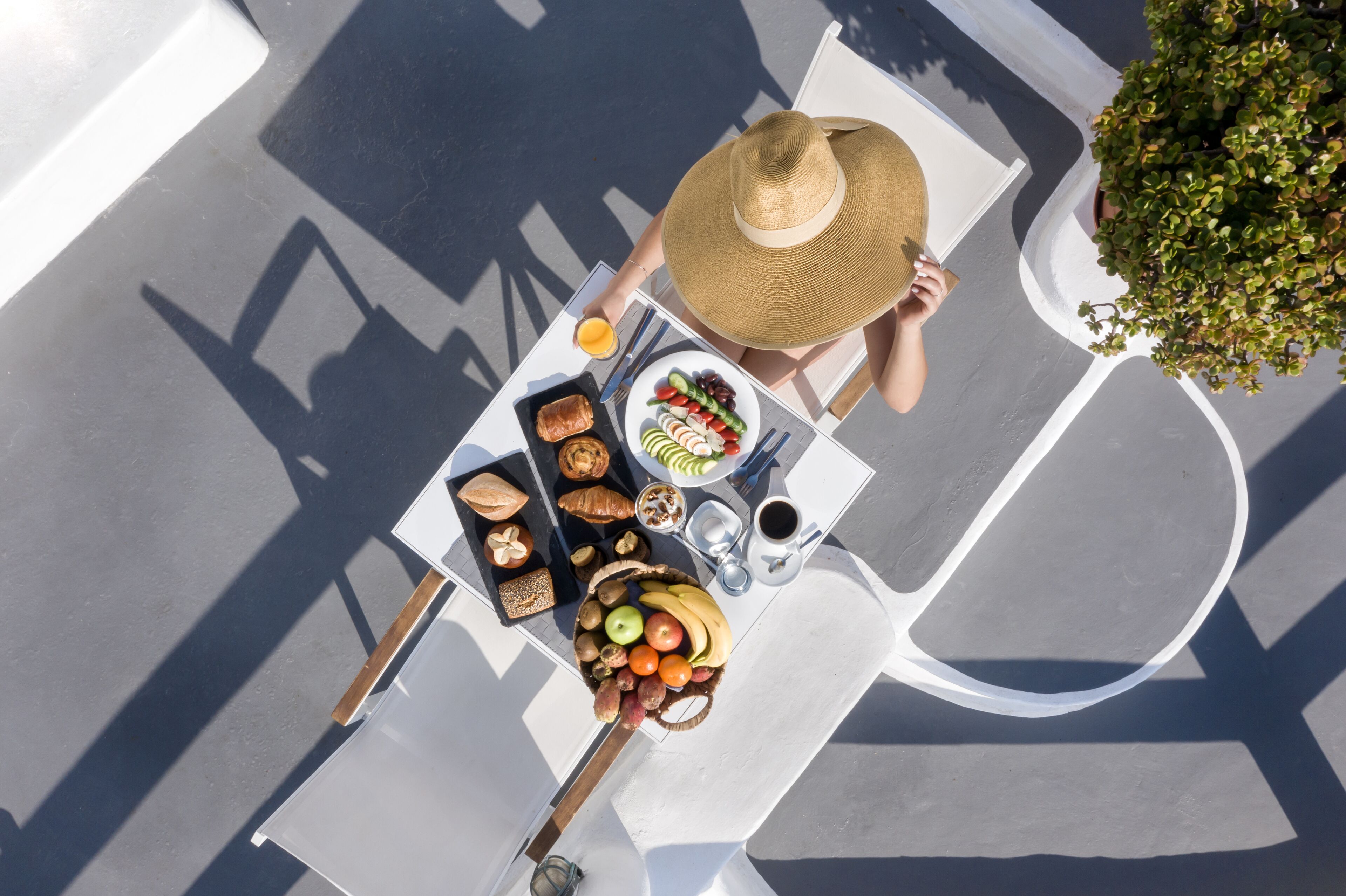 A top-down view of a dining table with food, a drink, and a straw hat.