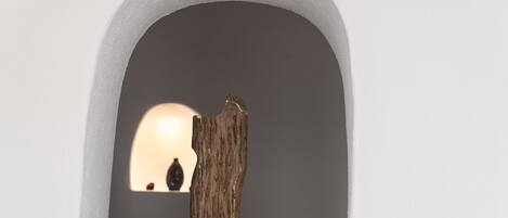 A wooden sculpture in a white arched niche.