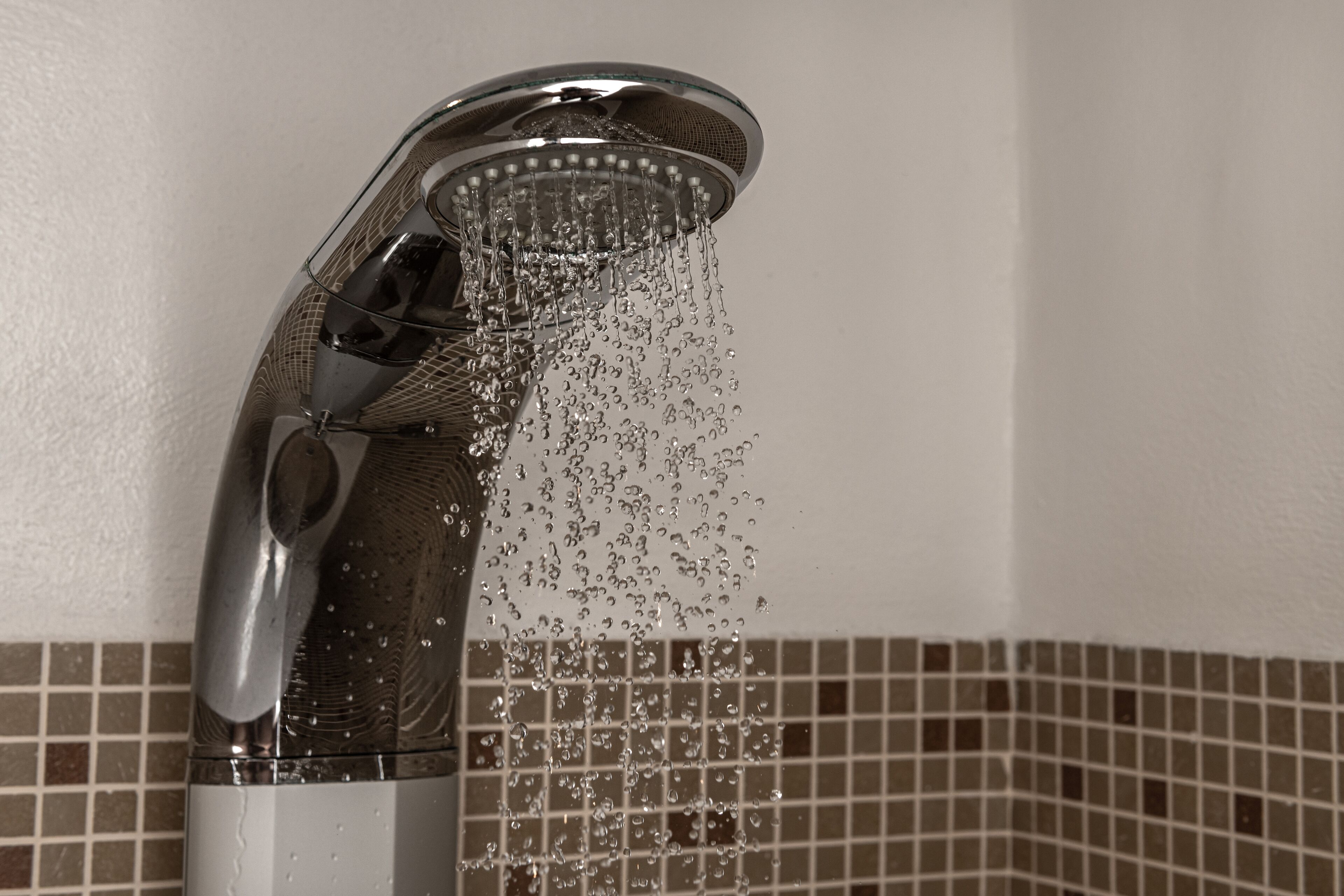 A showerhead with water flowing from it.