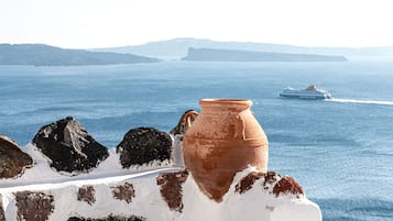 A coastal view with a white wall and a terracotta pot.