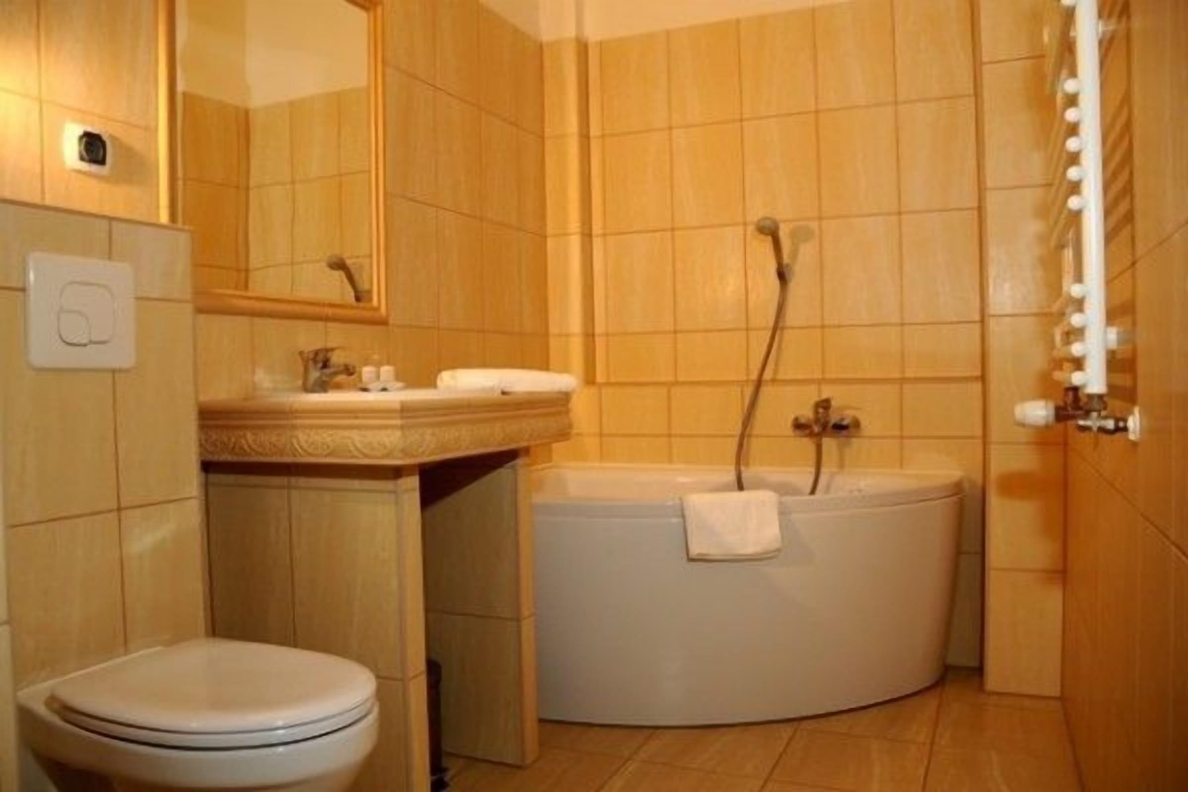 Un baño con inodoro, lavamanos y bañera.