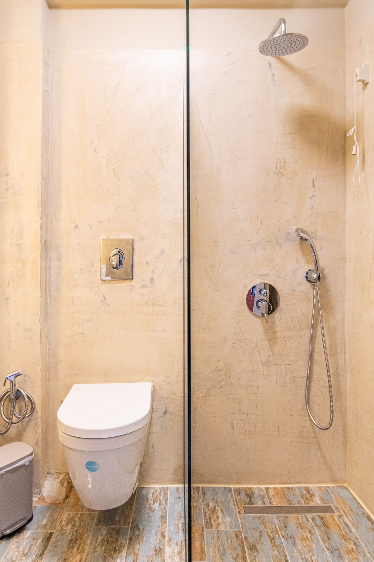 A bathroom with a toilet, a shower, and a bidet.