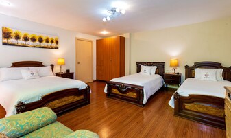 Habitación de hotel con dos camas, un armario, un cuadro y un ventilador de techo.
