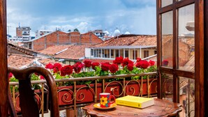 A balcony with a table, a cup, and a book. - Hotel Boutique Los Balcones (Cuenca)